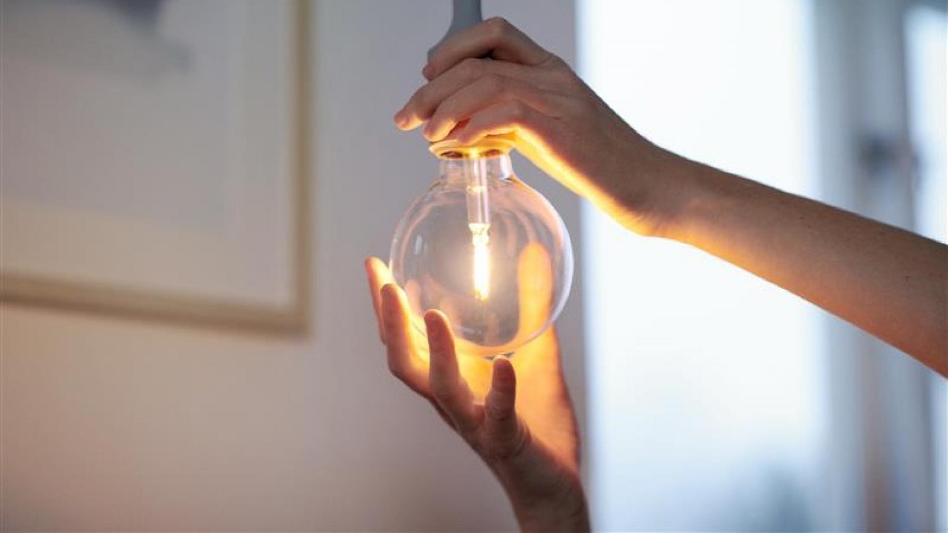 Hand som byter glödlampa