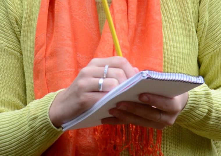 Skriver i anteckningsblock