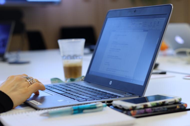 bild på en hand och en dator på ett skrivbord 