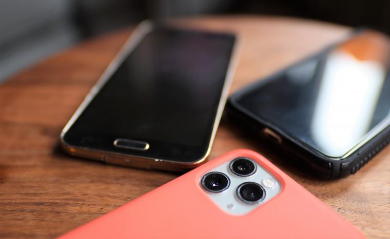 Tre mobiltelefoner på ett bord