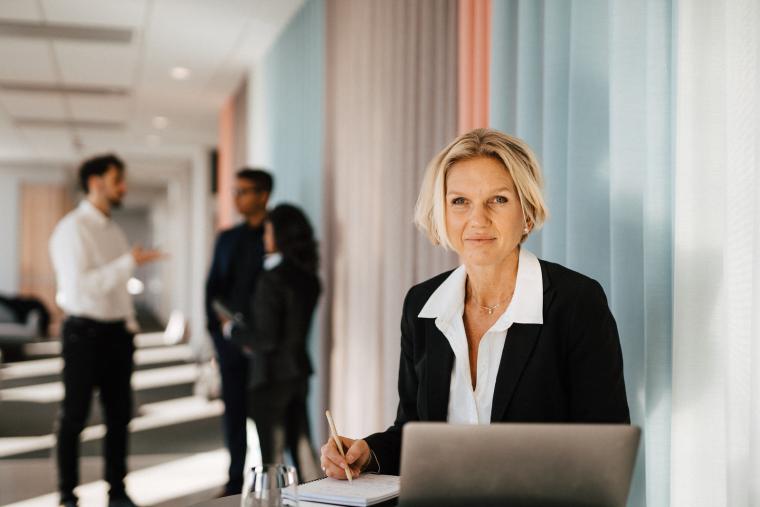 Kvinna i kavaj vid skrivbord