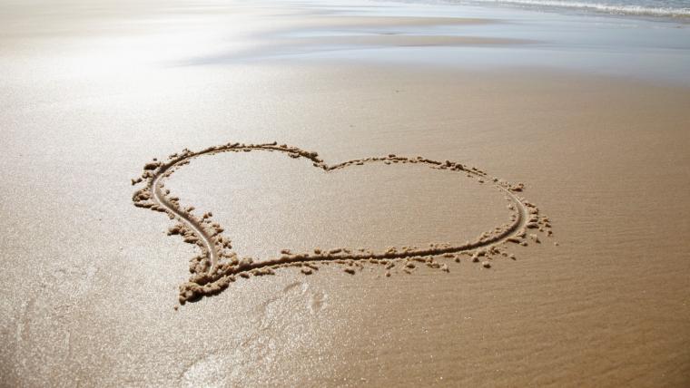 Ett hjärta ritat på en sandstrand