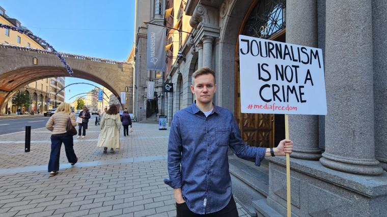 Joakim Medin med plakat "Journalist is not a crime"