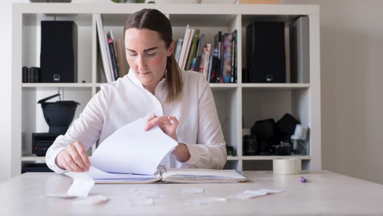 En kvinna sitter vid ett skrivbord och håller på med kvitton
