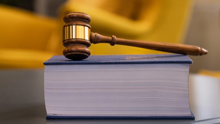 En lagbok med en ordförandeklubba ovanpå